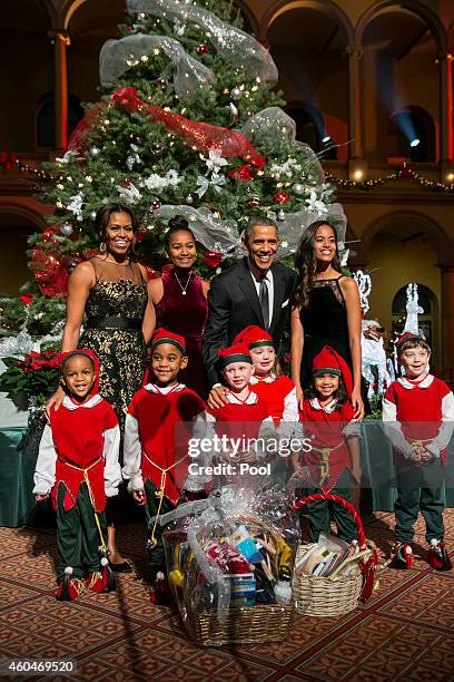 President Barack Obama , first lady Michelle Obama and daughters Sasha and Malia pose with "elves" prior to the taping of TNT's "Christmas in...