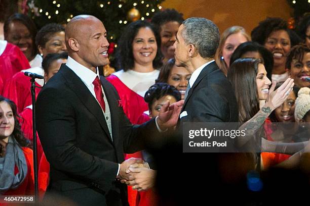 President Barack Obama, right, shakes hands with Dwayne "The Rock" Johnson, left, during the taping of TNT's "Christmas in Washington" program on...