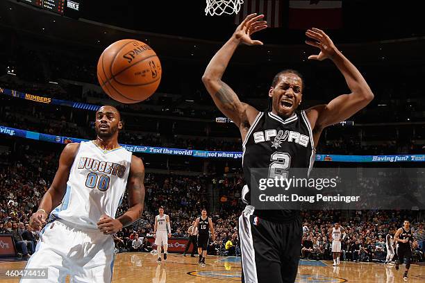 Kawhi Leonard of the San Antonio Spurs looses control of the ball against Darrell Arthur of the Denver Nuggets at Pepsi Center on December 14, 2014...