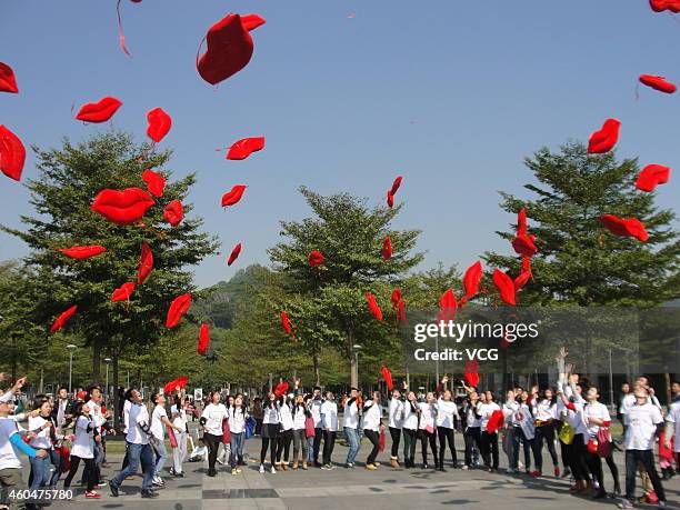 Flash mob carrying red lip dolls promotes the idea of rejecting indifference on December 14, 2014 in Shenzhen, Guangdong province of China. Rejecting...