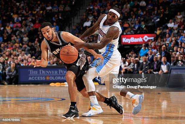 Cory Joseph of the San Antonio Spurs and Ty Lawson of the Denver Nuggets collide as they go for the ball at Pepsi Center on December 14, 2014 in...