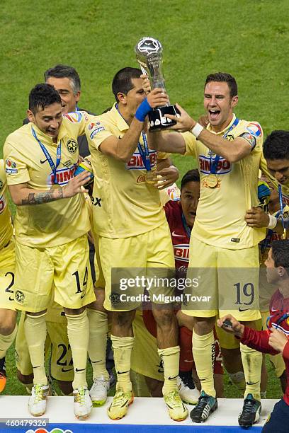 Rubens Sambueza, Jesús Molina and Miguel Layún of America lift the trophy after winning the final second leg match between America and Tigres UANL as...