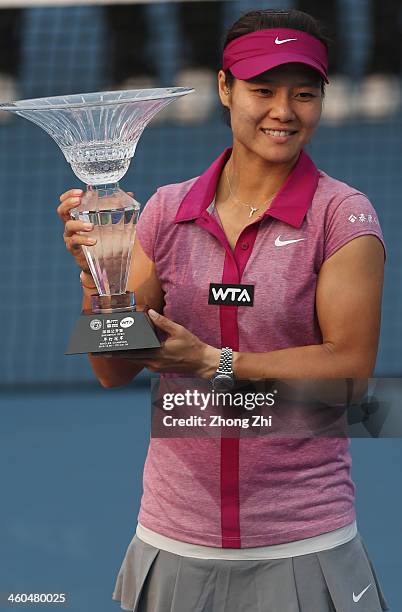 Na Li of China holds the champion trophy after winning her match against Shuai Peng of China on day eight of the WTA Shenzhen Open at Shenzhen...