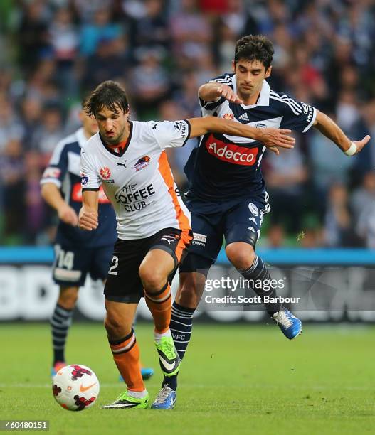 Thomas Broich of the Roar and Guilherme Finkler of the Victory compete for the ball during the round 13 A-League match between the Melbourne Victory...