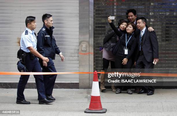 Group of friends take a 'selfie' together outside the pro-democracy protest site in the Causeway Bay district of Hong Kong on December 15, 2014....