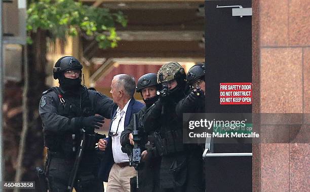 Hostage runs to safety outside the Lindt Cafe, Martin Place on December 15, 2014 in Sydney, Australia. Police attend a hostage situation at Lindt...