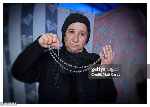 Iraqi Christian, who asked not to named, poses for a photograph in her tented home erected in the grounds of Mazar Mar Eillia Catholic Church, that...