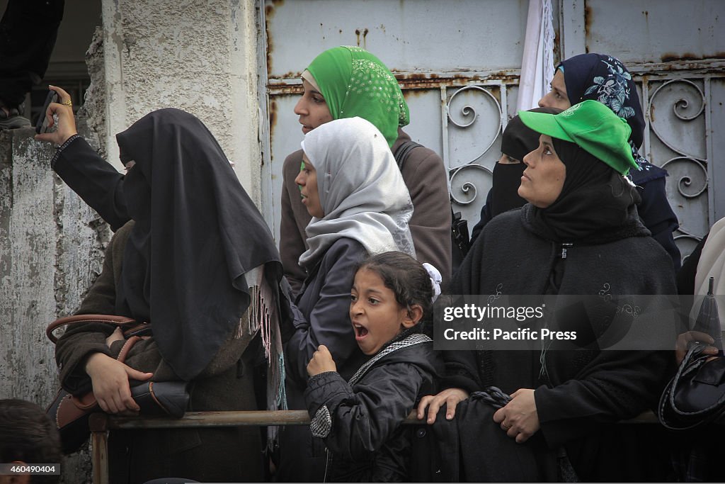 The Palestinians watching the members of al-Qassam Brigades...