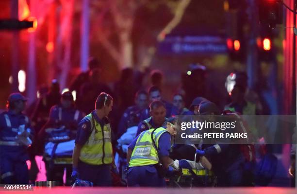 Australian paramedics work on an injured hostage as hostages are carried out of a cafe in the central business district of Sydney on December 16,...