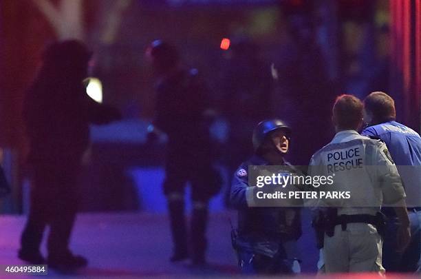 Australian police carry out a hostage rescue at a cafe in the central business district of Sydney on December 16, 2014. Police stormed the Sydney...