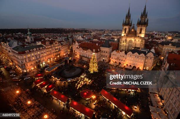 An illuminated Christmas tree is seen at the market at the Old Town Square in Prague, on December 15, 2014. In the background, the Church of Mother...