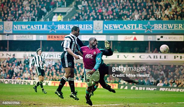 Newcastle forward Les Ferdinand beats Villa defender Ugo Ehigou and goalkeeper Mark Bosnich to head the winning goal during the Premier League game...