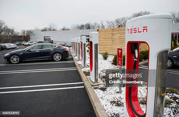 Model S electric vehicle sits parked in front of a supercharger station stands at the Tesla Motors Inc. Gallery and Service Center in Paramus, New...