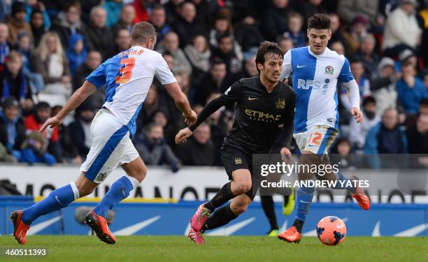 Manchester City's Spanish midfielder David Silva vies with Blackburn Rovers English defender Tommy Spurr and Blackburn Rovers English midfielder Ben...