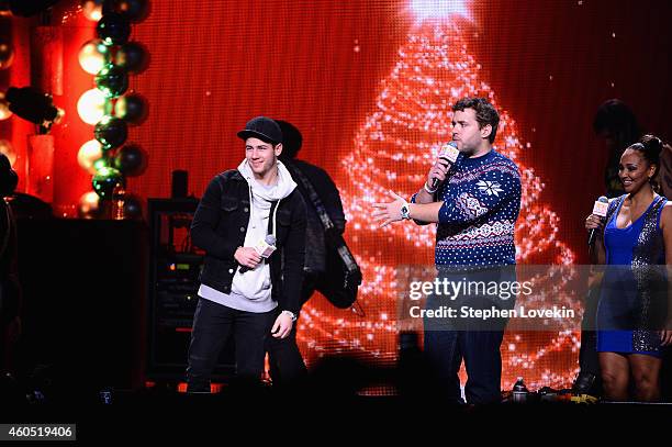 Nick Jonas, radio personalities Intern John and Danni of "The Kane Show" speak onstage during HOT 99.5s Jingle Ball 2014, Presented by Mattress...