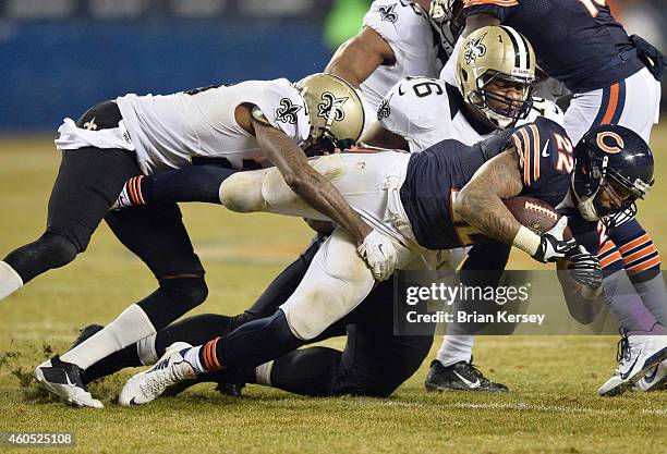 Matt Forte of the Chicago Bears is tackled by Keenan Lewis and Ben Grubbs of the New Orleans Saints during the second quarter at Soldier Field on...