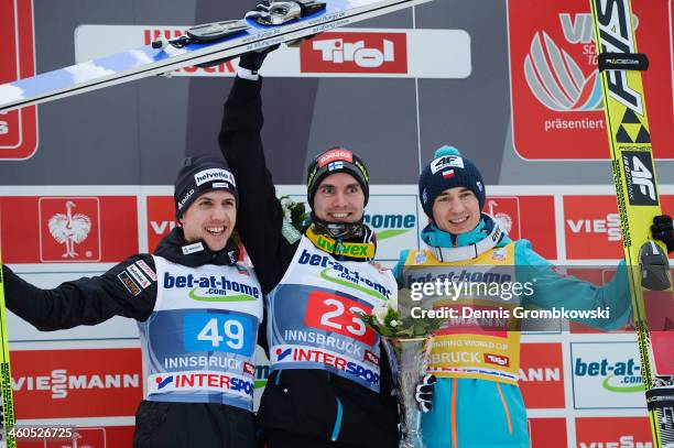 Simon Ammann of Switzerland, Anssi Koivuranta of Finland and Kamil Stoch of Poland pose at the podium after the competition on day 2 of the Four...