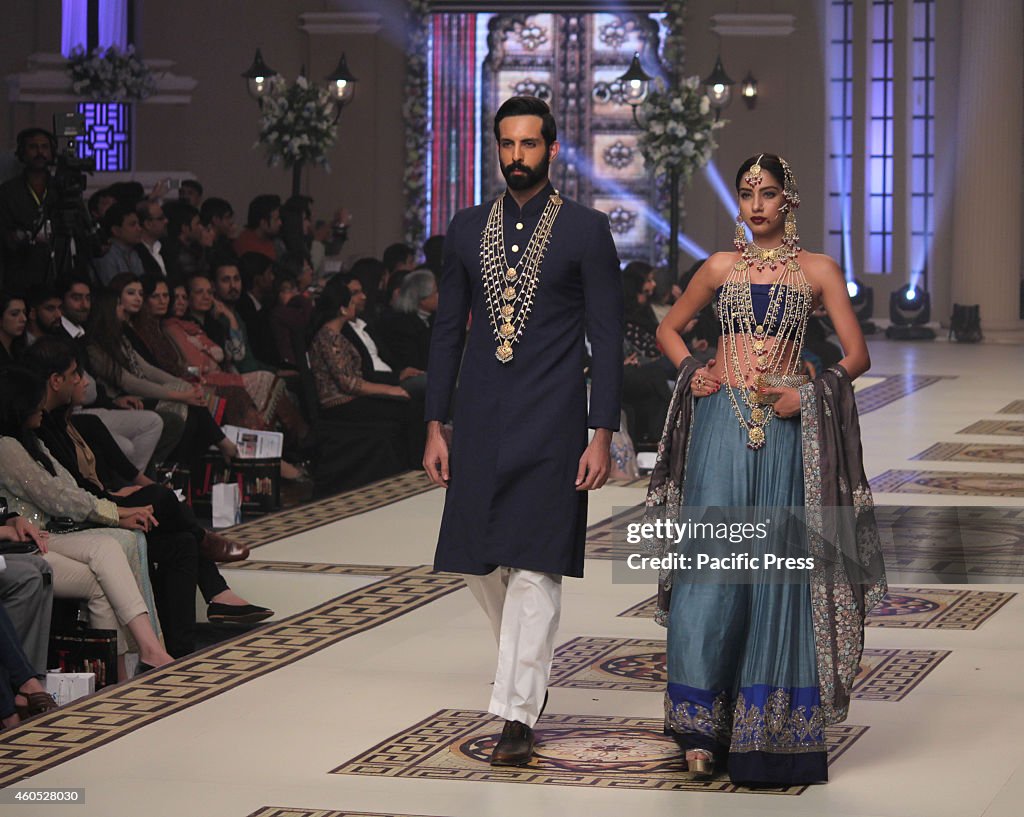 Pakistani models present the creations of different...