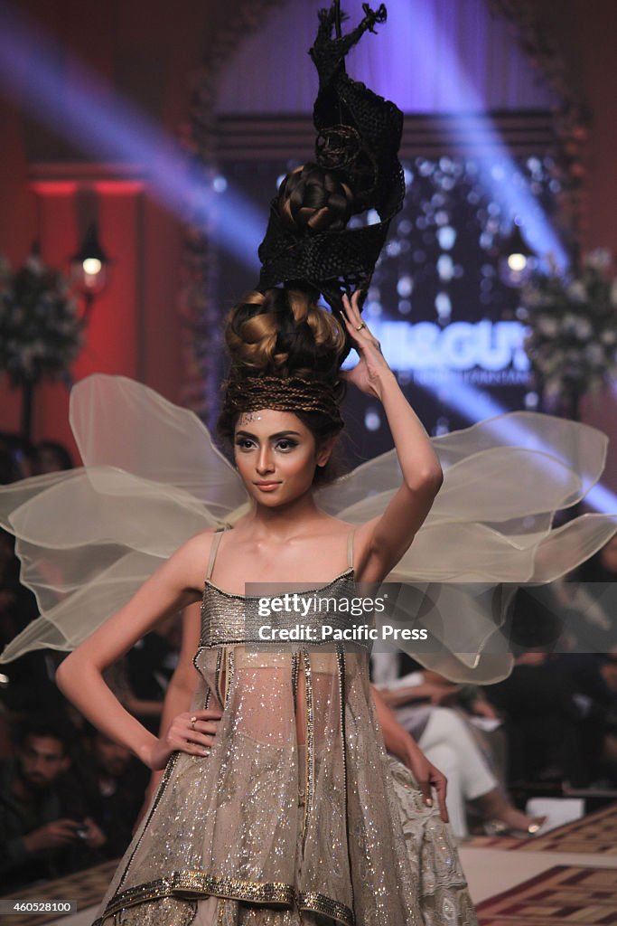 Pakistani model presents the creations of different...