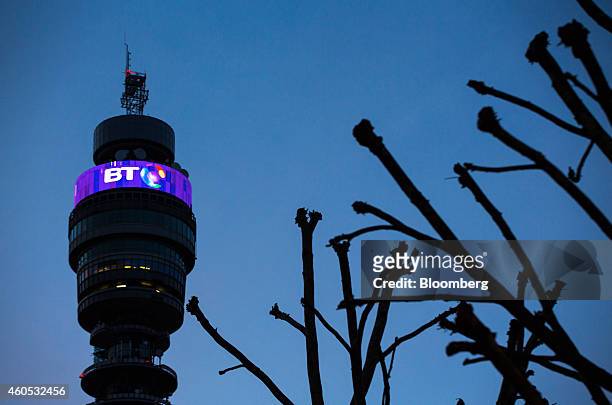An illuminated BT logo sits above communications equipment on the BT Tower, operated by BT Group Plc, at dusk in London, U.K., on Monday, Dec. 15,...