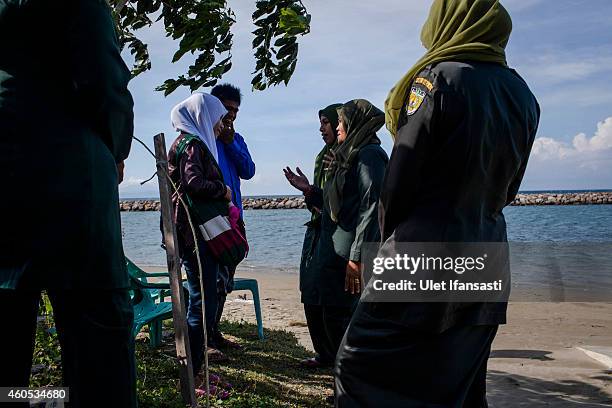 Members of the female sharia police known as Wilayatul Hisbah speak to a young couple after they were caught sitting too close to each other in beach...