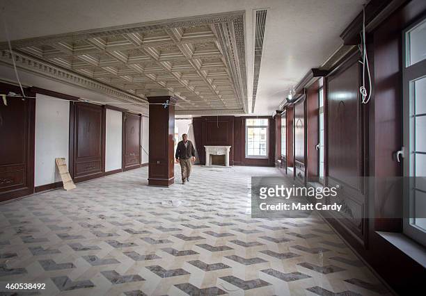 Construction worker walks through a reception room downstairs in the replica White House, a $20million villa being built inside Dream City, a new...