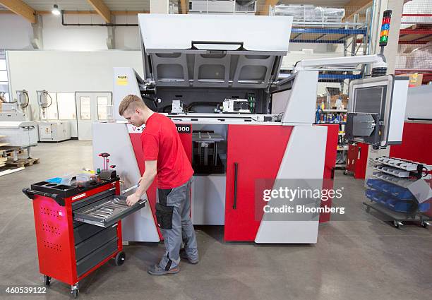 An employee selects a hand tool as he assembles a VX1000 large format 3-D printer at the Voxeljet AG 3-D printing plant in Friedberg, Germany, on...