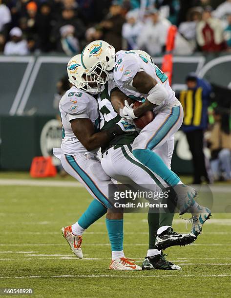 Tight End Jeff Cumberland of the New York Jets bobbles a pass when hit by Linebacker Jelani Jenkins that is intercepted by Safety Rashad Jones of the...