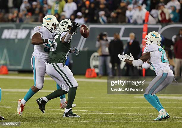 Tight End Jeff Cumberland of the New York Jets bobbles a pass when hit by Linebacker Jelani Jenkins that is intercepted by Safety Rashad Jones of the...