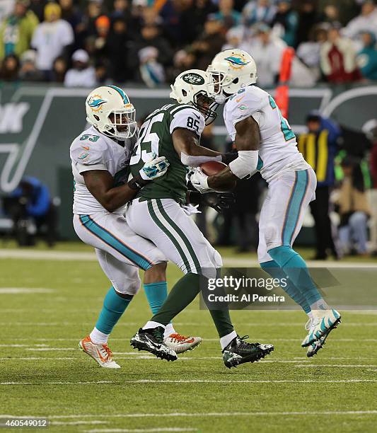 Tight End Jeff Cumberland of the New York Jets bobbles a pass when hit by Linebacker Jelani Jenkins that is intercepted by Safety Rashad Jones of the...