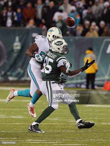 Tight End Jeff Cumberland of the New York Jets bobbles a pass when hit by Linebacker Jelani Jenkins that is intercepted by Safety Rashad Jones of the...