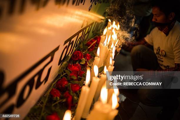 An Indian activist lights a candle during a vigil to mark the second anniversary of the fatal gang-rape of a student in the Indian capital, at the...