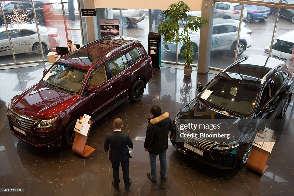 A customer, right, checks out the latest Lexus LX570, left,