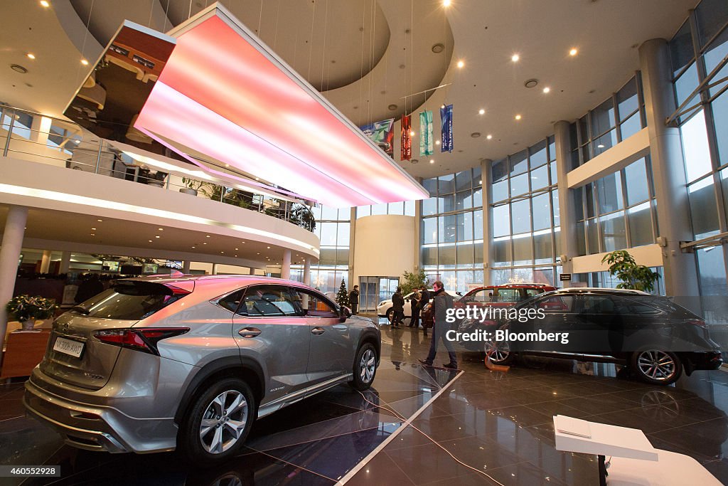 Visitors inspect a display of Lexus automobiles for sale in