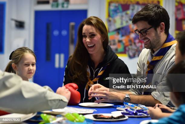 Britain's Catherine, Duchess of Cambridge sitting beside Scout Leader Carlos Lopez-Plandolit , learns about disability by wearing a boxing glove to...
