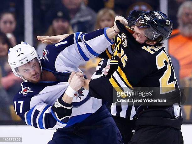 Matt Fraser of the Boston Bruins fights James Wright of the Winnipeg Jets in the first period during the game at TD Garden on January 4, 2014 in...