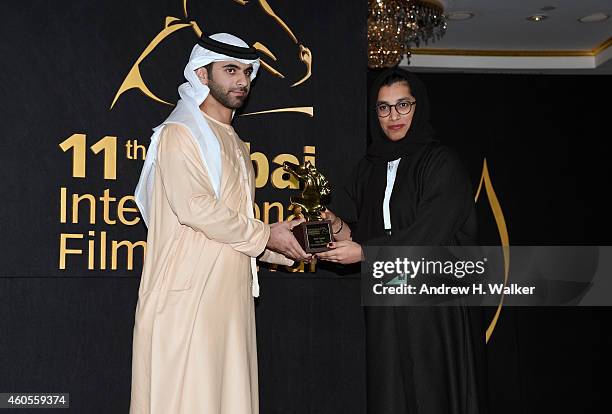 Sheikh Mansoor bin Mohammed bin Rashid Al Maktoum and director Aisha Alzaabi with the Muhr Emirati Best Film award for "The Other Dimension" on stage...