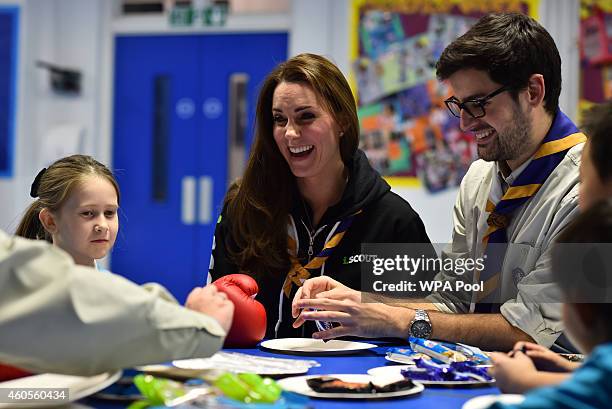 Britain's Catherine, Duchess of Cambridge sitting beside Scout Leader Carlos Lopez-Plandolit , learns about disability by wearing a boxing glove to...