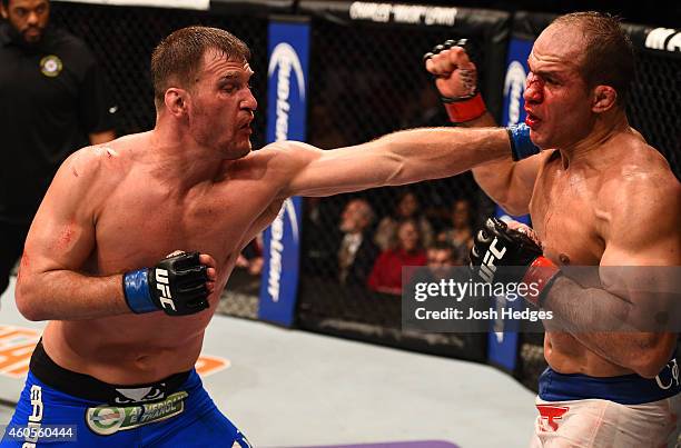 Stipe Miocic punches Junior Dos Santos of Brazil in their heavyweight fight during the UFC Fight Night event at the U.S. Airways Center on December...