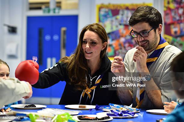 Britain's Catherine, Duchess of Cambridge sitting beside Scout Leader Carlos Lopez-Plandolit , learns about disability by wearing a boxing glove to...