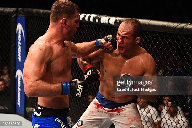 Stipe Miocic punches Junior Dos Santos of Brazil in their heavyweight fight during the UFC Fight Night event at the U.S. Airways Center on December...