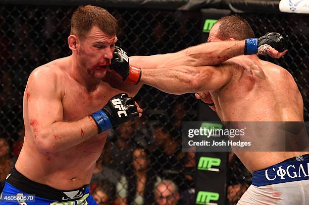 Junior Dos Santos of Brazil and Stipe Miocic trade punches in their heavyweight fight during the UFC Fight Night event at the U.S. Airways Center on...