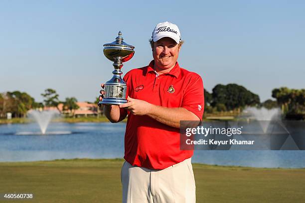 Brad Fritsch of Canada smiles with the Championship trophy on the 18th hole green of the Champion Course following his seven-stroke victory in the...