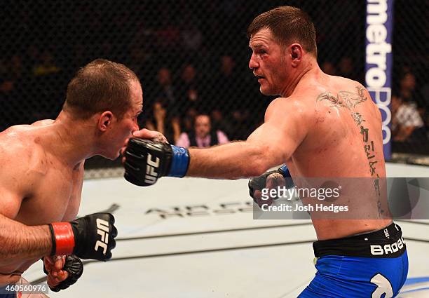 Stipe Miocic punches Junior Dos Santos of Brazil in their heavyweight fight during the UFC Fight Night event at the U.S. Airways Center on December...