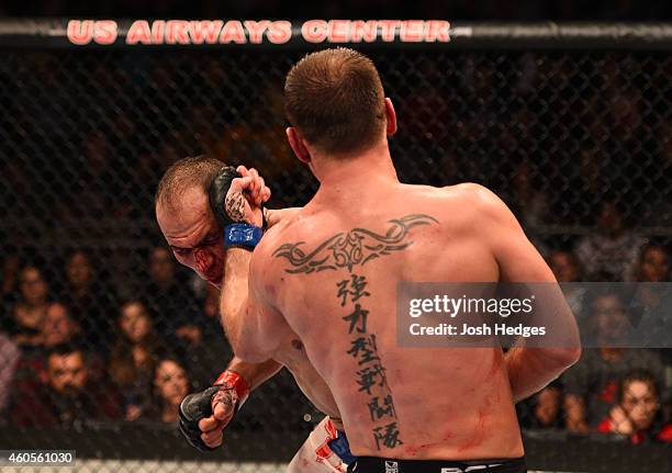 Stipe Miocic punches Junior Dos Santos of Brazil in their heavyweight fight during the UFC Fight Night event at the U.S. Airways Center on December...