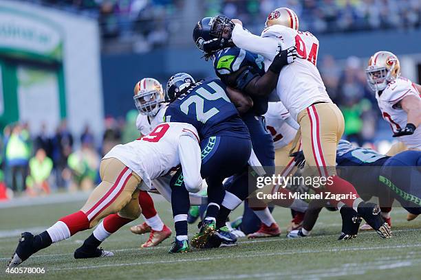 Aldon Smith of the San Francisco 49ers tackles Marshawn Lynch of the Seattle Seahawks as Justin Smith of the 49ers battles James Carpenter of the...