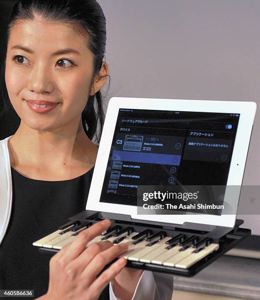 Model displays the 'C.24' wireless piano keyboard which can be used as iPad case during its launching on December 16, 2014 in Tokyo, Japan. The...