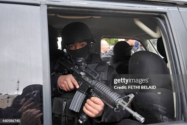 Tunisian special forces stand guard in a vehicle as Tunisian presidential candidate and former prime minister Beji Caid Essebsi gives a speech during...