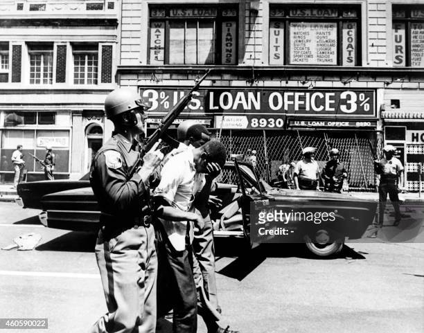 Policemen arrest afro american suspects in a Detroit street on July 25, 1967 during riots that erupted in Detroit following a police operation.