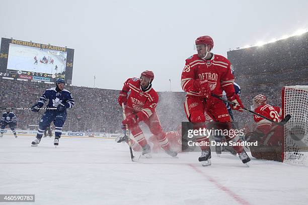 Phil Kessel of the Toronto Maple Leafs looks for the rebound as Kyle Quincey and Brian Lashoff of the Detroit Red Wings defend the low post in the...